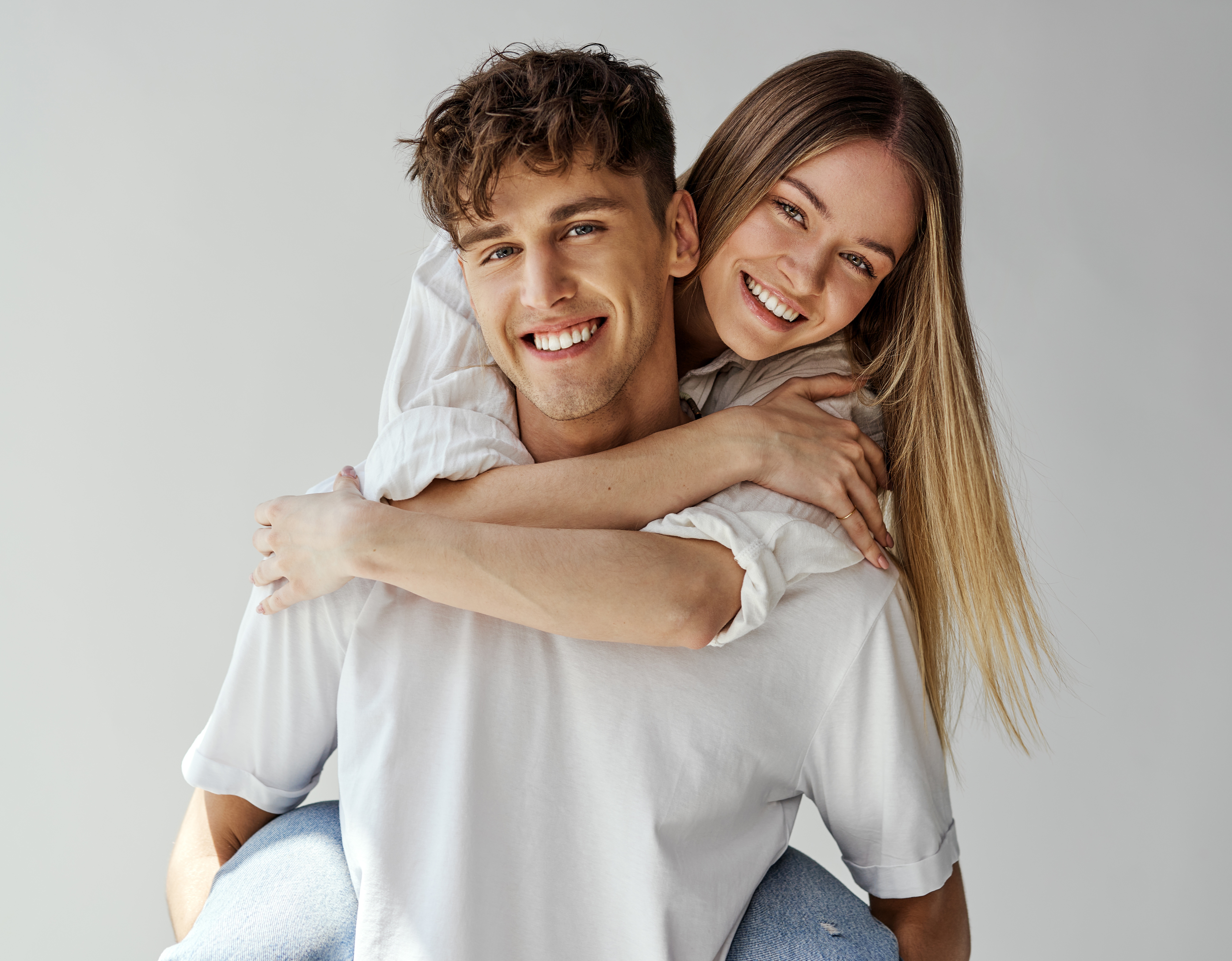 A smiling couple embracing in white shirts