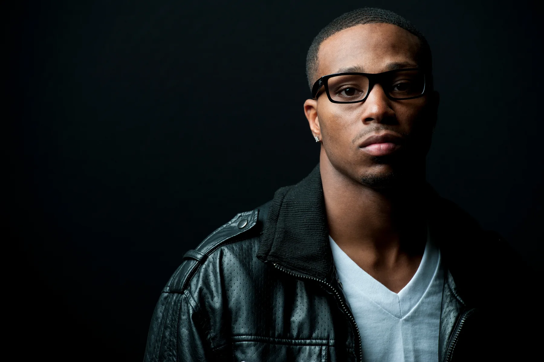 A man wearing glasses and a dark jacket