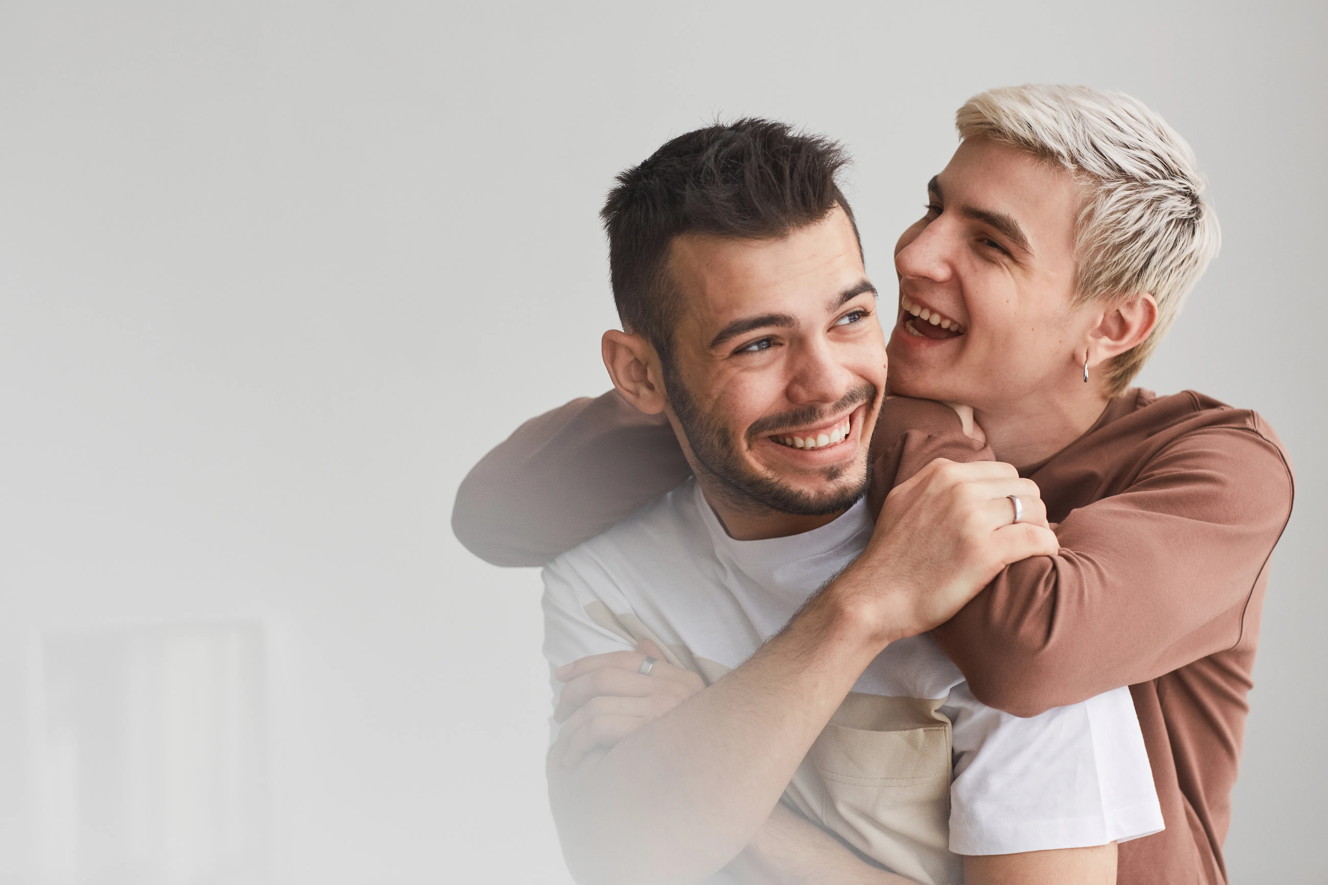 Two men smiling and embracing